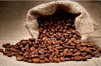 chicchi di caffè arabica marroni che si spandono da un sacco di iuta marrona