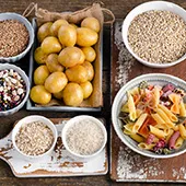 tavola apparecchiata con cibi con carboidrati come patate pasta farina integrale